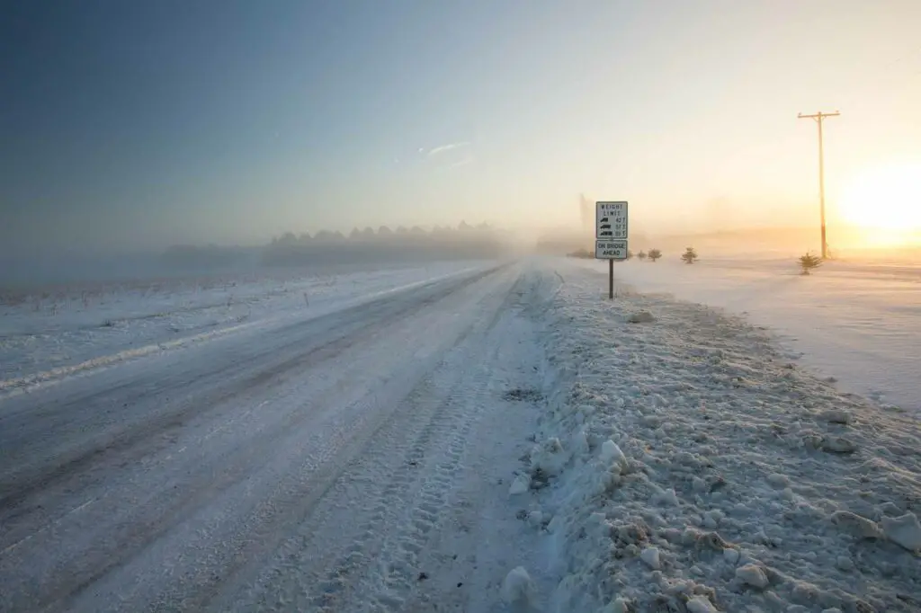 soplando nieve a través de la carretera