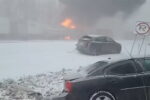 Schneesturm mit Fahrzeugen und Feuerexplosion in der Ferne.