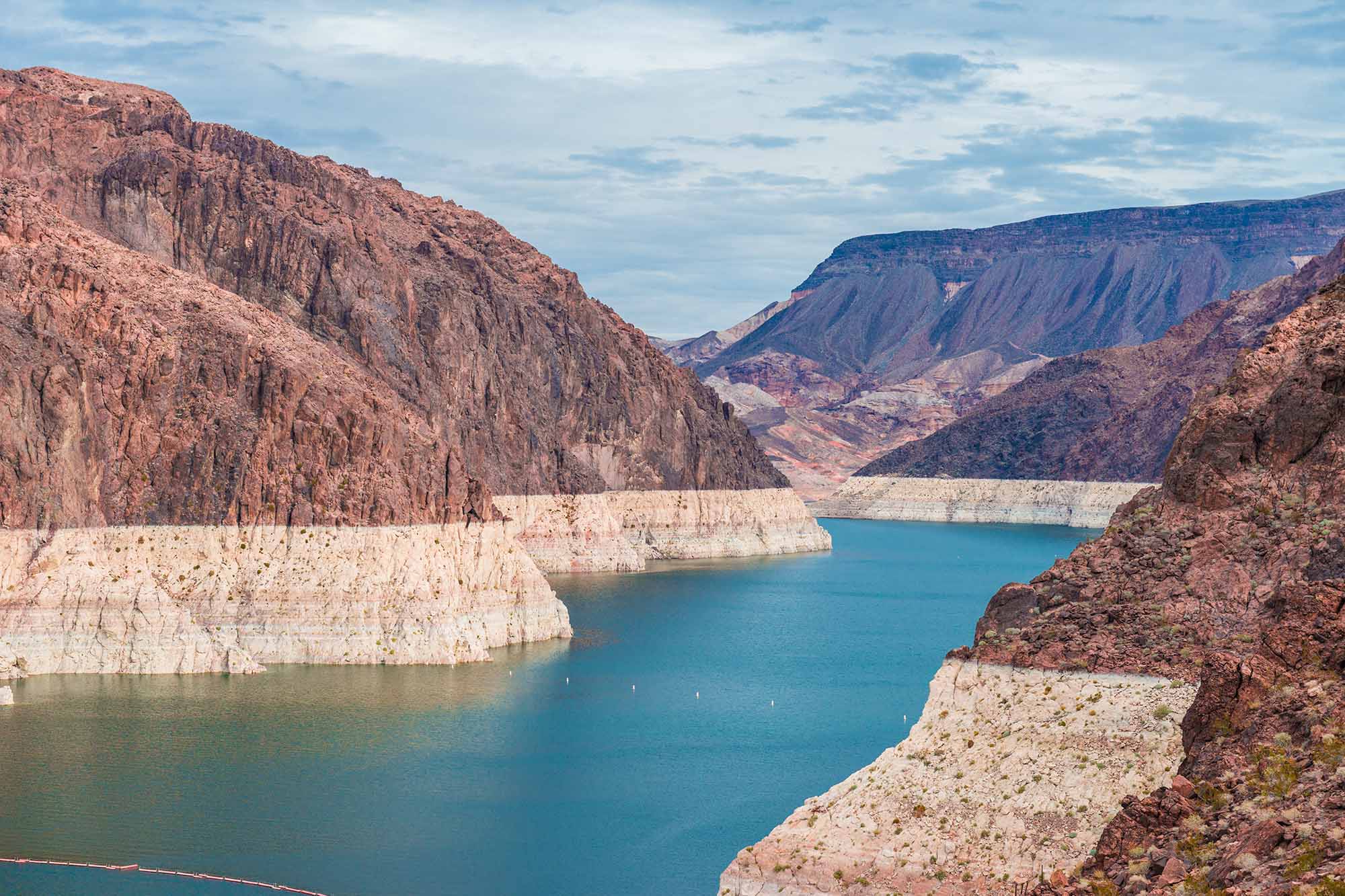 Deep canyon with turquoise river and rocky cliffs.